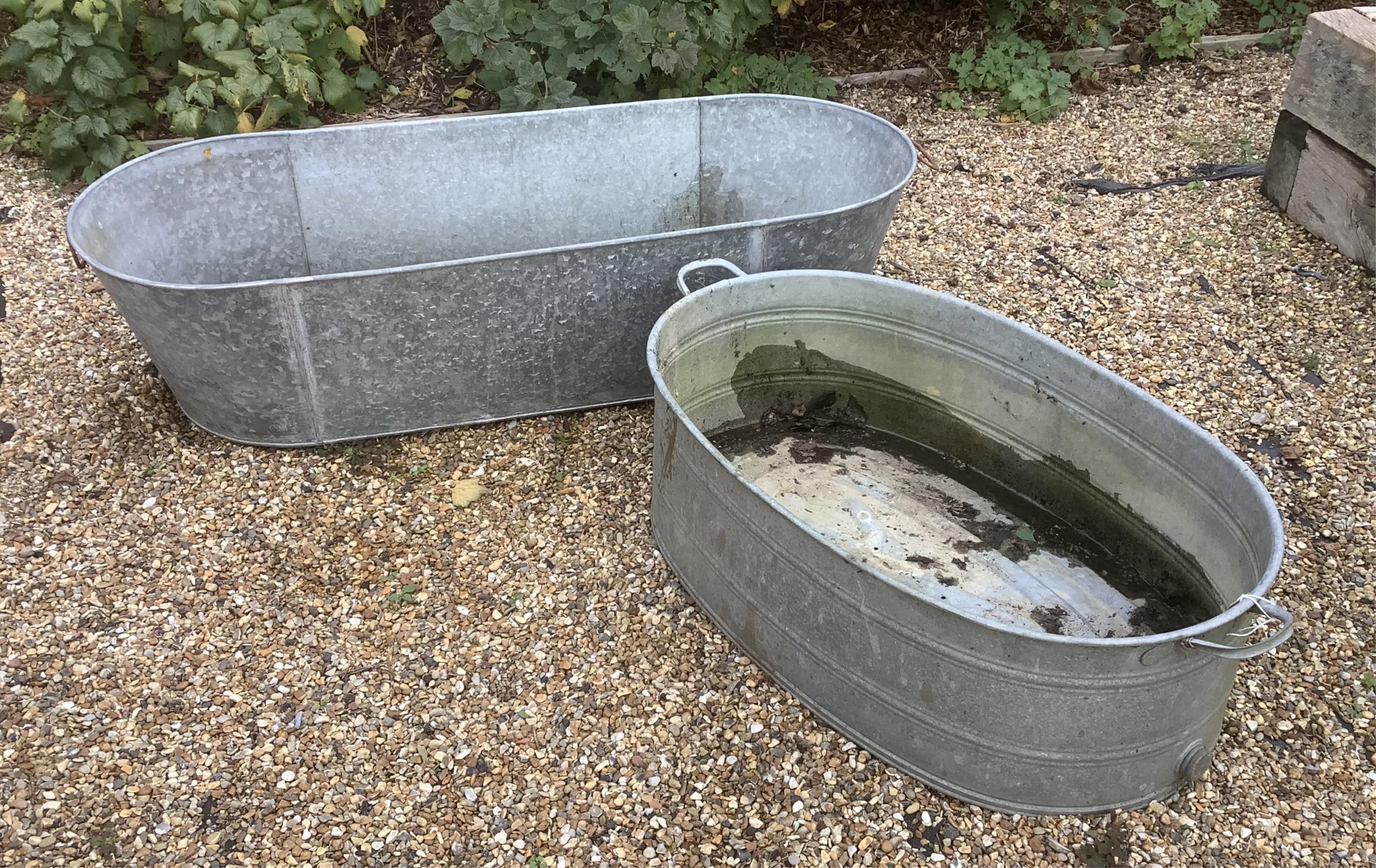 Two galvanised baths / tubs, 136cm and 104cm, planting removed, Condition - weathered otherwise good, smaller is drilled